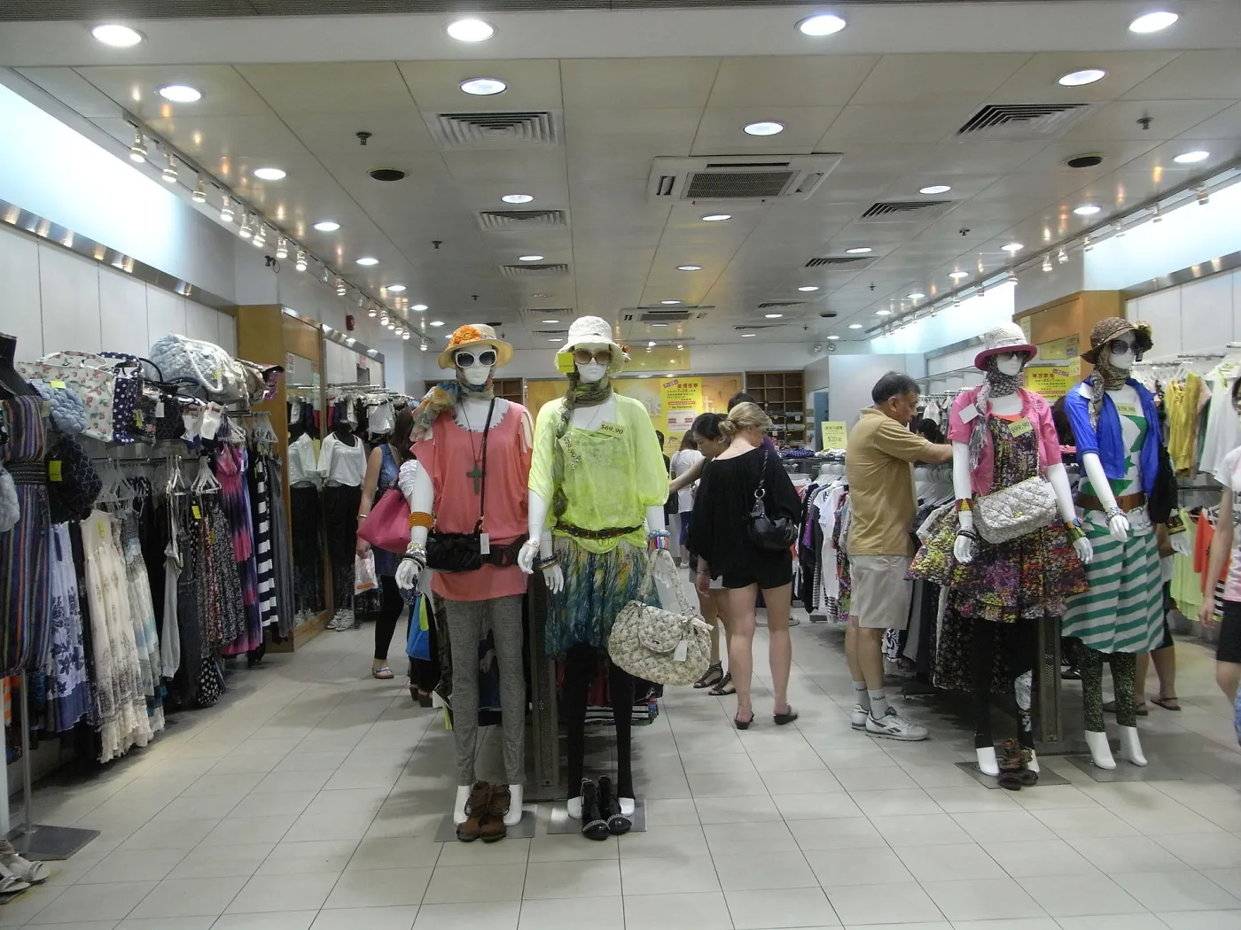 Interieur van een In-Fashion kledingwinkel aan Granville Road in Tsim Sha Tsui, Hongkong, met rekken en schappen vol kleding onder heldere winkelverlichting.